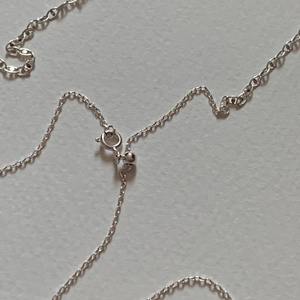 Detailed macro view of S925 silver cable chain with spring clasp and adjustable slide bead