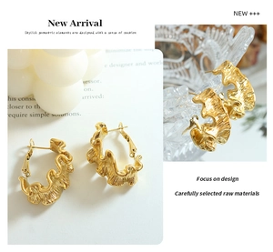 Détail macro de boucles d'oreilles créoles dorées plissées avec placage or 18 carats