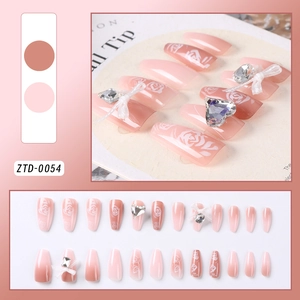 Detail of gradient pink press-on nails with white roses, 3D heart gems and bow accents