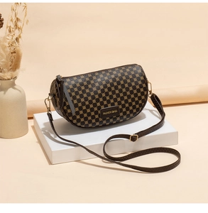 Detailed view of dark brown saddle bag with geometric dot patterns and adjustable strap