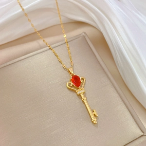 Luxurious gold crown key necklace with red teardrop gemstone and sparkling diamonds