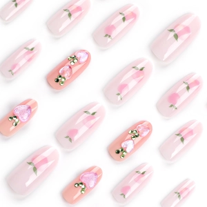 Pink peach press-on nails with 3D heart gems and hand-painted fruit art on white base