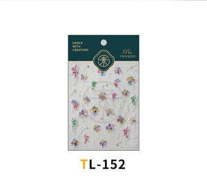Detail of gradient flower nail stickers with half-round pearls on dark green packaging