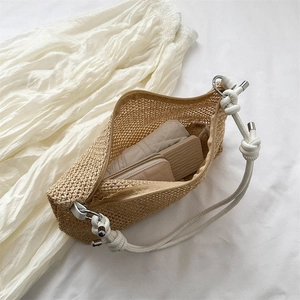 Handwoven straw tote bag with white rope handles and large capacity on white linen background