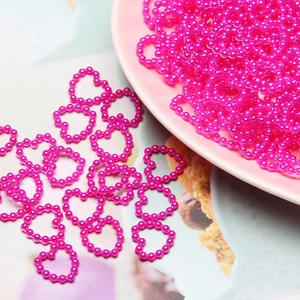 Close-up of pink heart-shaped ABS imitation pearl beads for DIY nail art and crafts