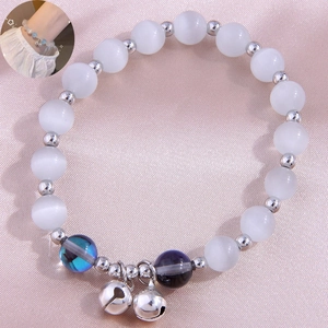 Elegant cat eye stone bracelet with silver bells on pink silk, minimalist luxury jewelry