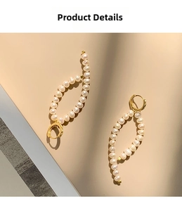 Detailed macro view of S925 silver long baroque pearl earrings with golden metal clasps