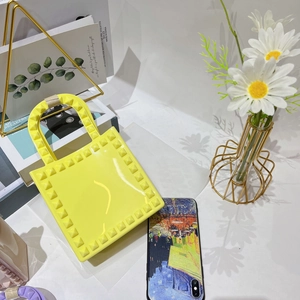 Close-up of a yellow PVC jelly bag with rivet studs in an INS style lifestyle setting