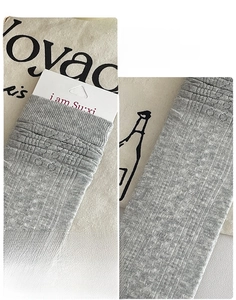 Detail of light grey slouch socks featuring breathable hollow knit and 3D heel design