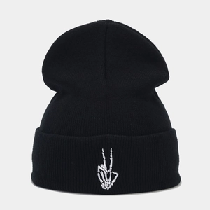 Détail de la broderie main de squelette blanche sur un bonnet en maille noir