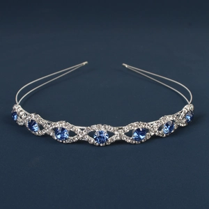 Close-up of wavy silver tiara featuring blue gemstones and sparkling rhinestones