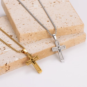 Minimalist double-layered gold and silver cross necklaces on a textured stone surface