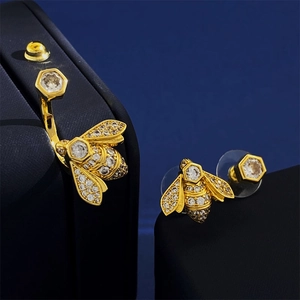 Asymmetric bee stud earrings with sparkling cubic zirconia in a gold vintage finish