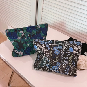 Detail of blue floral jacquard makeup bags with secure metal zip closure for travel