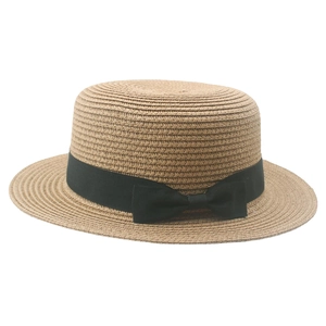 Classic summer straw boater hat with a chic black ribbon bow on white background
