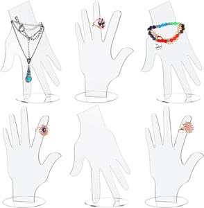 Detailed views of clear acrylic hand-shaped jewelry stands for rings and bracelets