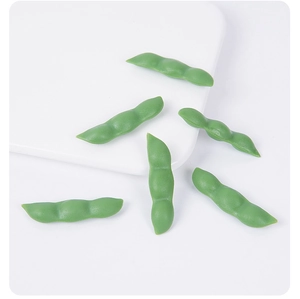 Close-up of artificial green PVC edamame pea pods with realistic matte texture