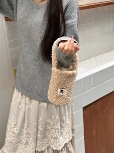 Beige plush cup carrier bag made of soft sherpa fabric with cute cartoon patch detail