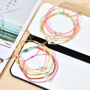 Detail of bohemian handmade beaded bracelets with natural freshwater pearls and slide knot