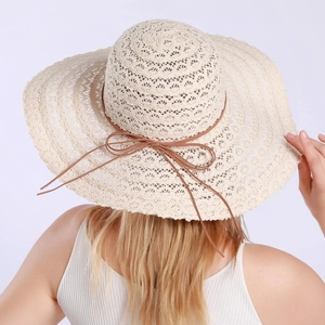 Close-up of beige lace sun hat featuring breathable hollow knit and a brown ribbon bow