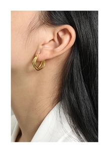 Close-up of minimalist layered golden hoop earrings in S925 silver worn by a model