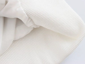 Vue détaillée du poignet en maille côtelée blanche et doublure de la veste en tweed