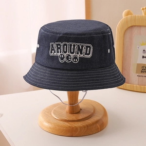 Close-up of kids denim bucket hat with letter embroidery and white chin strap