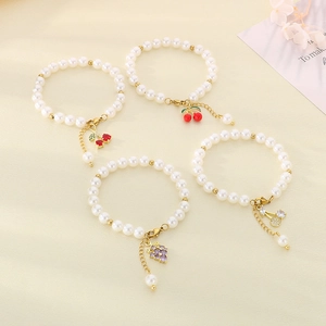 Elegant beaded pearl bracelets featuring gold fruit pendants with sparkling zircons
