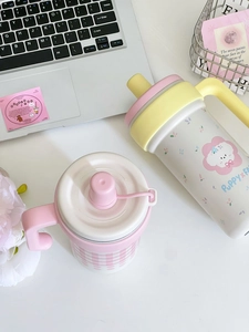 Detail of insulated pink plaid and cream puppy illustration coffee mugs with handle