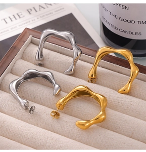 Close-up of gold and silver irregular C-shaped earrings with S925 silver posts