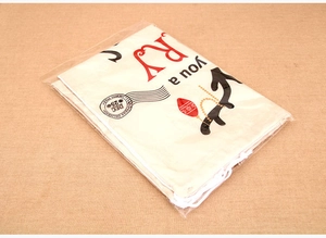 Detail view of a white canvas Christmas gift bag with festive red and black prints