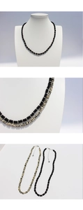 Detail view of black onyx and cow pattern stone beaded necklace with silver clasp