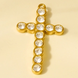 Detailed view of a gold-plated stainless steel cross pendant with inlaid clear crystals