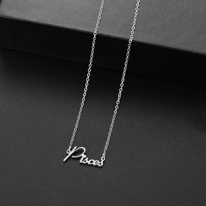 Macro shot of silver stainless steel necklace with Pisces constellation letter pendant