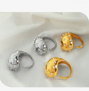 Macro detail of 18K gold and silver waterdrop rings with micro-pave crystals and pearls