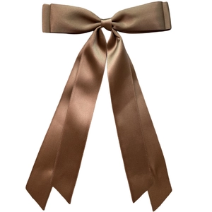 Close-up of a glossy brown satin ribbon bow hair clip with elegant long hanging tails