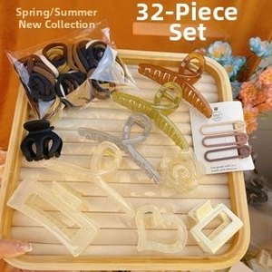Close-up of 32-piece hair accessories set with clips and elastic bands in a wooden tray