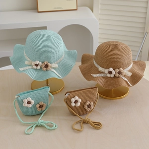 Detail of straw hat and matching bag set with lace ribbons and crochet flower accents
