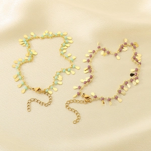 Detail of titanium steel anklets with colorful resin beads on beige silk fabric