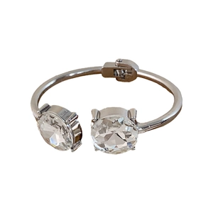 Polished silver cuff bracelet featuring two large round-cut clear crystals on a white background