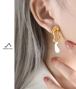 Detailed side view of a model wearing asymmetric white drip stainless steel earrings