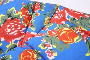 Detailed macro view of vibrant floral print and quilted texture on a blue winter jacket