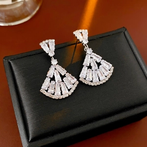 Detailed shot of silver fan-shaped earrings with zircon crystals on black jewelry box
