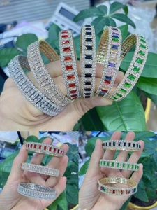 Fashionable gold-plated bangle with baguette-cut colored stones and pavé set crystals