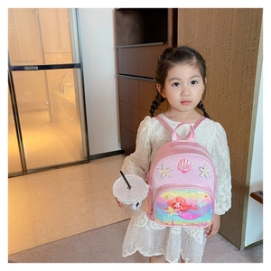 Close-up of pink glitter girls backpack with 3D shell and mermaid cartoon pattern