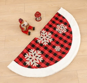 Detail of red and black buffalo plaid Christmas tree skirt with plush white border and snowflakes