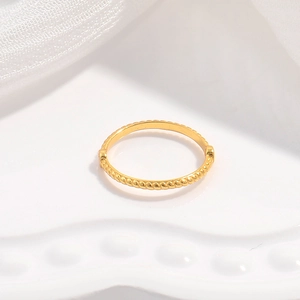 Macro detail of a twisted gold S925 sterling silver bead ring with a rope texture design