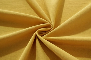Close-up of yellow washed cotton fabric texture showing professional spiral fold pattern