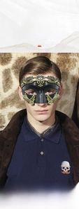 Detailed close-up of Roman masquerade mask with ornate gold relief patterns and black finish