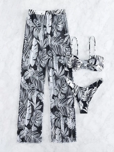 Flat lay of three-piece bikini set including mesh trousers with palm leaf print